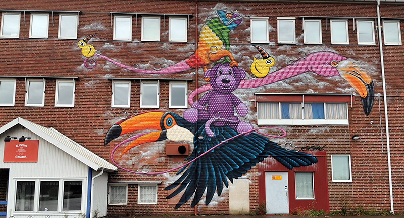 Aktivitetshuset Sågen med en målning på sig som symboliserar en fågel och diverse andra färgglada samt fantasifulla figurer.