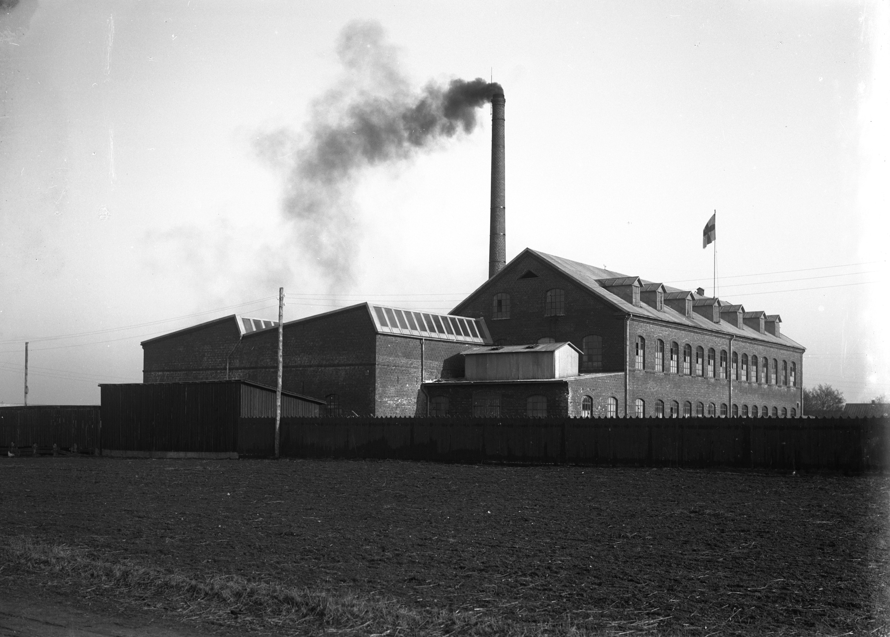 Läderfabriken i Klippan med rök kommande från den stora skorstenen