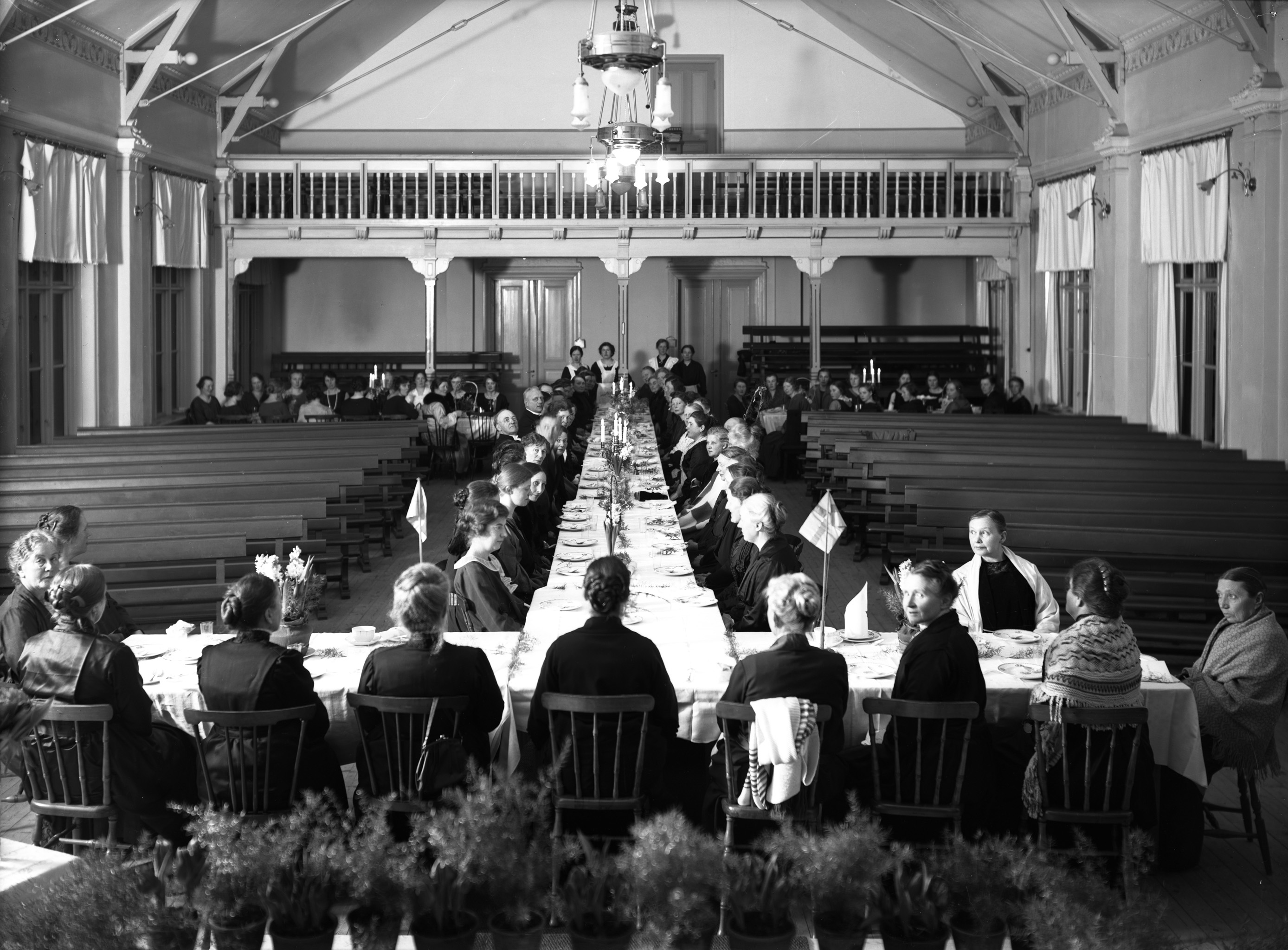 Bild på människor som deltar i en middag inne i Kyrksalshuset
