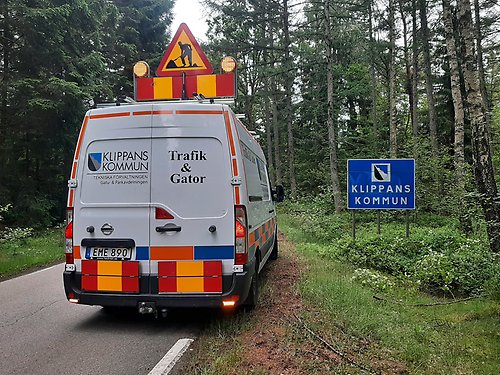 Tekniska förvaltningens skåpbil som stannat till vid en skogs väg med en Klippans kommuns inträdesskylt jämte sig vid vägen.